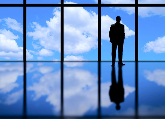 business man looking out window at clouds website