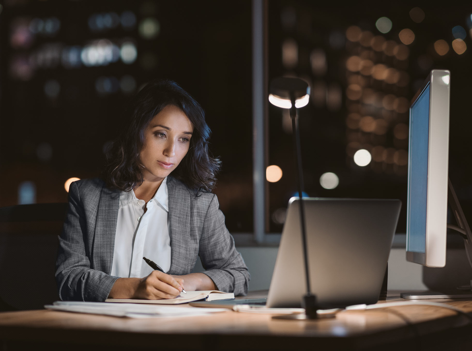 business woman working late at computer in office website