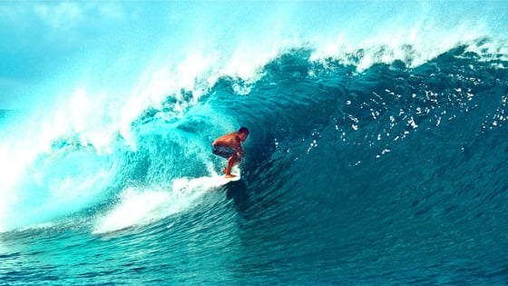 surfer rides blue wave resized