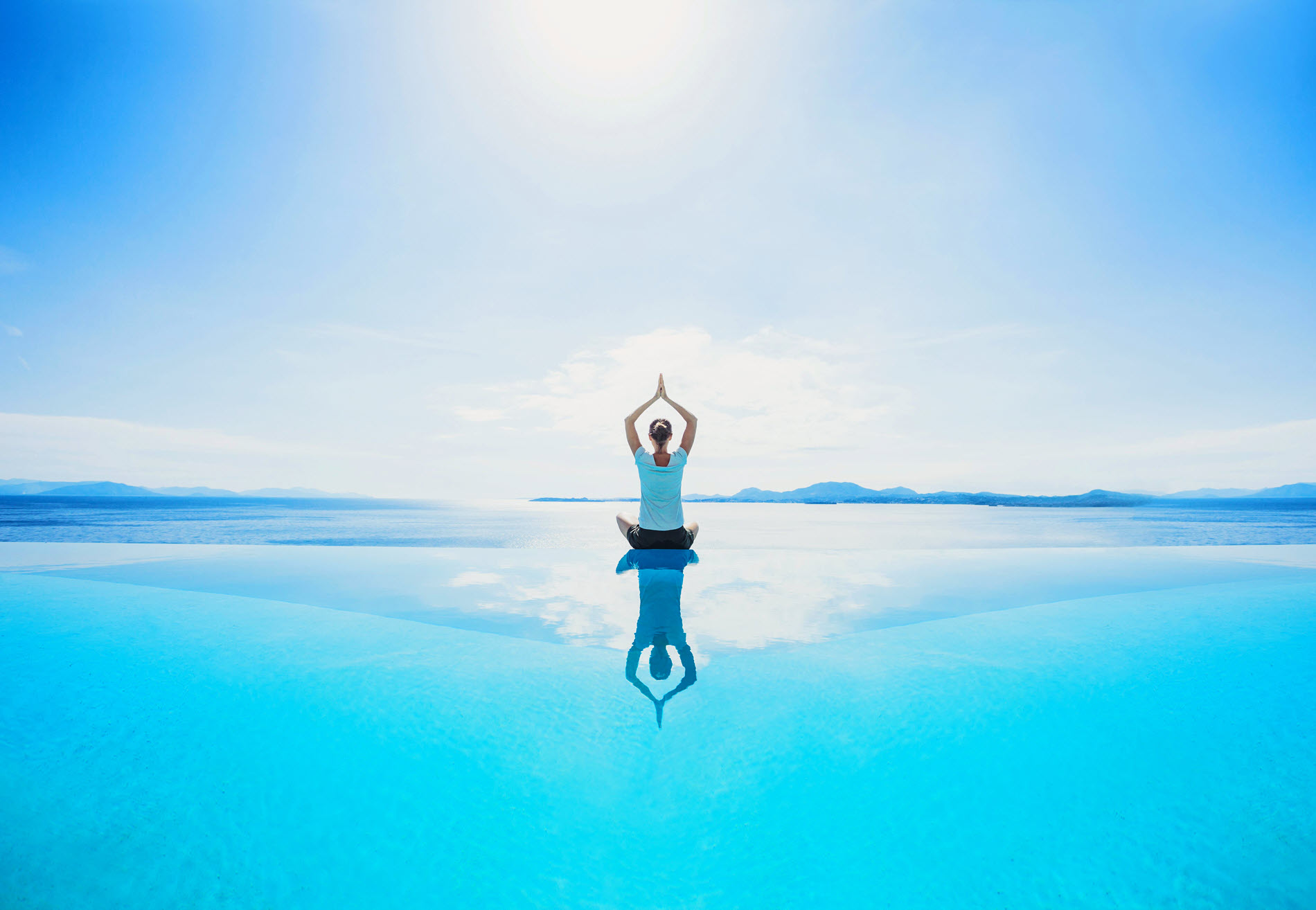 woman doing yoga near water website